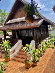 a small house with potted plants in front of it at Villa Phathana Royal View Hotel in Luang Prabang