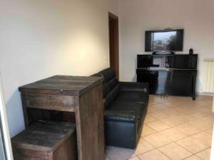 uma sala de estar com um sofá de couro e uma televisão em House Serapide Airport em Melito di Napoli