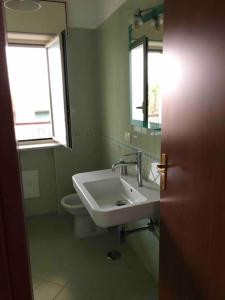 uma casa de banho com um lavatório, um WC e um espelho. em House Serapide Airport em Melito di Napoli