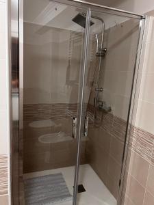 La salle de bains est pourvue d'une douche avec une porte en verre. dans l'établissement Da Nonna Maria, à Celano