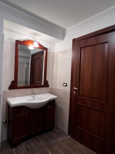 ein Badezimmer mit einem Waschbecken und einer Holztür in der Unterkunft Da Nonna Maria in Celano