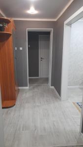 una sala de estar vacía con un pasillo con una puerta en Двухкомнатная в 4 микрорайоне, en Uralsk