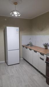 uma cozinha com um frigorífico branco e um balcão em Двухкомнатная в 4 микрорайоне em Oral