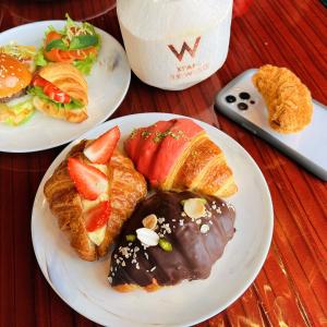 two plates of food with bread and fruit on a table at W XIAN Hotel in Xi'an