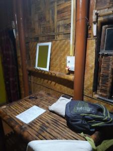 Una habitación con una mesa de madera con una bolsa. en Ayang Okum River Bank Bamboo Cottage Kaibortta Gaon, en Nagargaon