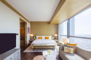 a bedroom with a bed and a large window at MGM Shanghai West Bund in Shanghai