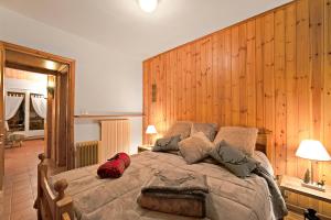 a bedroom with a large bed with a wooden wall at Chaberton Romantic Retreat - Happy Rentals in Claviere