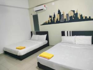 two beds sitting next to each other in a room at Starlight Homestay The Venus Sitiawan in Seri Manjung