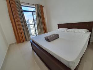 - un lit avec une serviette dans une chambre avec une fenêtre dans l'établissement CoolView Colombo, à Colombo