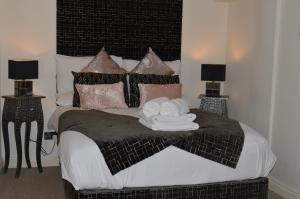 a bedroom with a black and white bed with two lamps at Benson House Box in Box