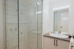 ein Bad mit einer Dusche und einem Waschbecken in der Unterkunft Comfort Inn Traralgon in Traralgon