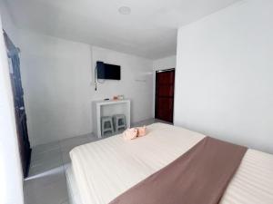 的住宿－MP Resort，白色卧室,配有带粉红色毛巾的床