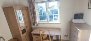 een kleine kamer met een bureau en een raam bij Shear Annexe Flat in Cambridge