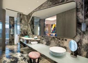 uma casa de banho com um lavatório e um espelho grande em W XIAN Hotel em Xi'an