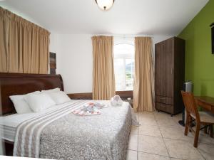um quarto com uma cama com duas bonecas em Hotel La Casa de la Abuela em Boquete