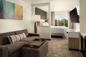 a hotel room with a couch and a bed at SpringHill Suites Dallas Arlington North in Arlington