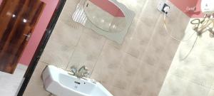 een badkamer met een wastafel en een douchegordijn bij New Hindusthan Hotel in Siliguri