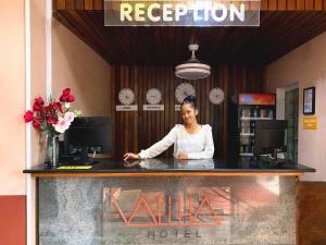 a woman standing behind a counter in a hotel at Valiha Hotel Antananarivo in Antananarivo
