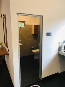 a bathroom with a toilet and a mirror at Beacon in Hikkaduwa