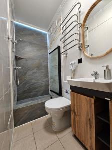 ein Bad mit einem WC, einer Dusche und einem Waschbecken in der Unterkunft Petropavlivska apartment in Kamjanez-Podilskyj