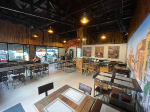ein Restaurant mit Tischen und Stühlen und eine Person im Hintergrund in der Unterkunft Twin Palms Hostel Phi Phi in Ko Phi Phi