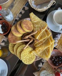 拉巴特的住宿－DAR LALLA Aicha 2，桌上的薄煎饼和一盘食物
