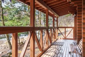 a porch of a wooden cabin with two benches at Mori no Kuni - Vacation STAY 03921v in Ōma