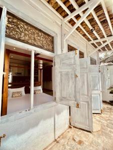 a room with white doors and a room with a bed at Secret Beach Talpe in Talpe