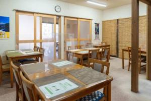 Mori no Kuni - Vacation STAY 03957v في Ōma: غرفة مع طاولات وكراسي وساعة على الحائط