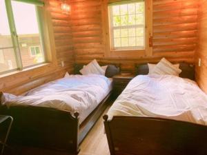 two beds in a room with two windows at Mori no Kuni - Vacation STAY 03790v in Ōma +18 photos