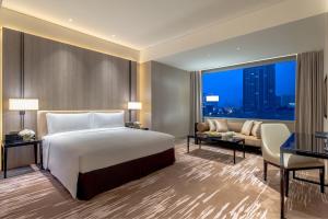 une chambre d'hôtel avec un lit et un canapé dans l'établissement Niccolo Chengdu, à Chengdu