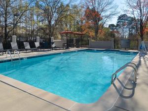 uma grande piscina com cadeiras e um guarda-sol em Candlewood Suites - Birmingham - Inverness, an IHG Hotel em Birmingham