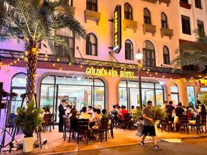 a group of people sitting outside of a restaurant at Golden Sea Hotel in Ha Long