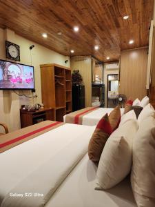 a hotel room with two beds and a flat screen tv at SaPa Retreat Condotel in Sapa