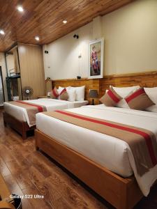 a hotel room with three beds in a room at SaPa Retreat Condotel in Sa Pa