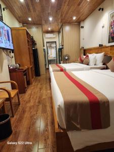 a hotel room with two beds and a flat screen tv at SaPa Retreat Condotel in Sapa