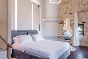 a bedroom with a bed with a stone wall at Athali Villa in Krousón