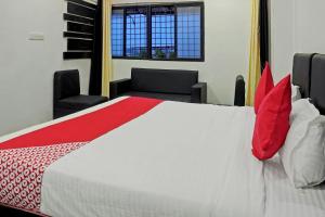 a bedroom with a large bed with red pillows at Gauri Shree Hotel in Bhopal