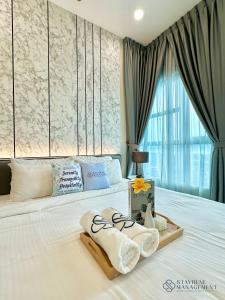 ein Schlafzimmer mit einem Bett mit Handtüchern darauf in der Unterkunft Melaka Ong Kim Wee Residences by Stayrene in Malakka