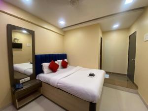 a bedroom with two beds and a mirror at Hotel Royal Grand - Near Mumbai International Airport in Mumbai