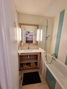 a bathroom with a sink and a mirror and a tub at Studio 4P vue piscine St Raphaël Valescure - Au cœur des Golfs in Saint-Raphaël +24 photos