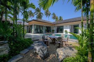 Una vista exterior de una villa con piscina. en Thammachard29 Resort Baangrood, en Thong Chai