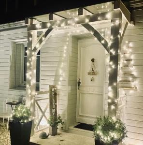 un arco con luces en una casa blanca en Douce Halte en Sautron