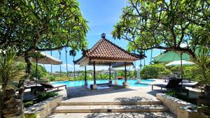 a pool at a resort with a gazebo at Nipuri Resort and Villas Seminyak by Kamara in Seminyak