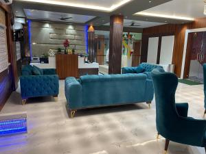 a lobby with two blue couches and a counter at THE SKYLITE HOTEL & BANQUET in Ara