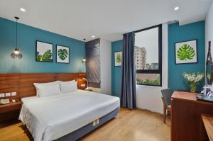 een slaapkamer met een groot wit bed, een bureau en een raam bij 22Land Classic Suites in Hanoi