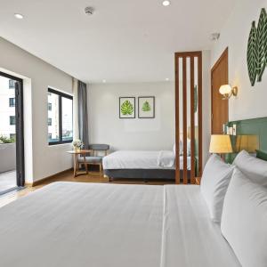 a bedroom with a white bed and a table at 22Land Classic Suites in Hanoi