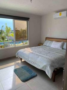 En eller flere senge i et værelse på Hermoso Apartamento con club de playa