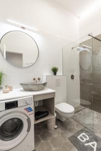 a bathroom with a washing machine and a toilet at Real Apartments Museum in Budapest