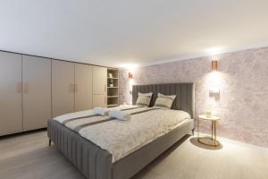 a bedroom with a large bed with white cabinets at Real Apartments Museum in Budapest